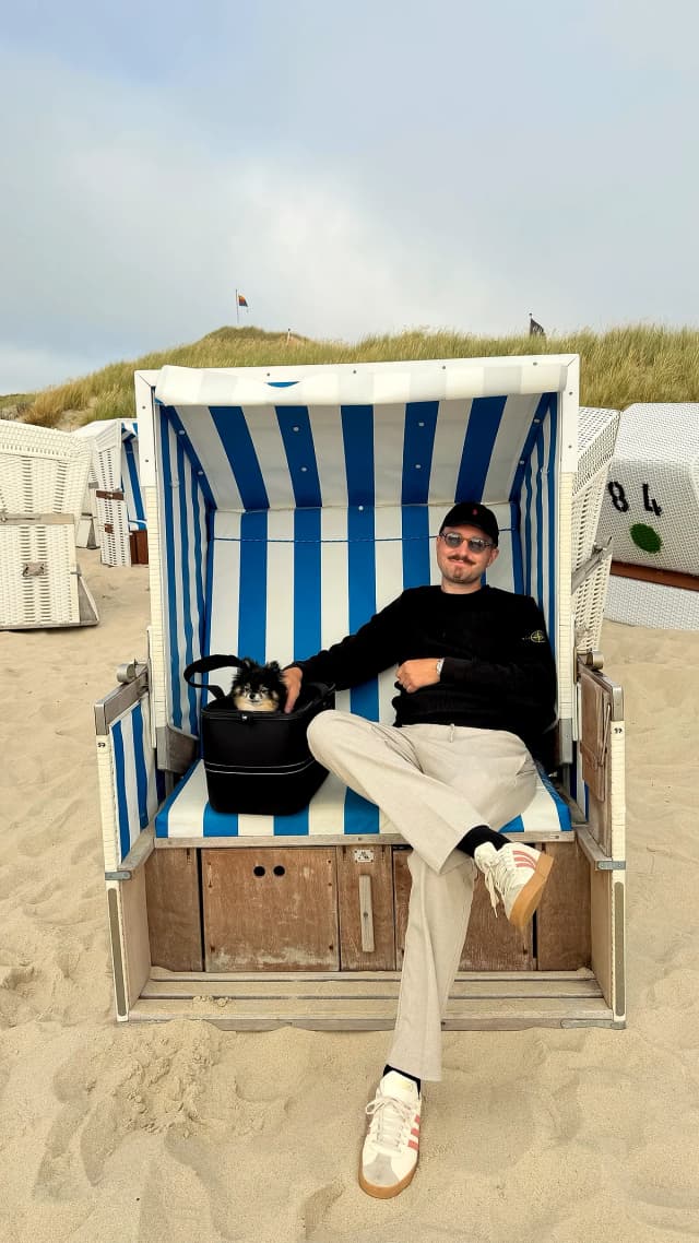Mann mit Hund im Strandkorb